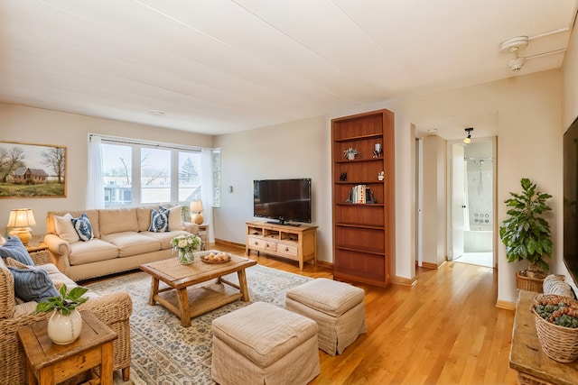 living room featuring light wood finished floors and baseboards