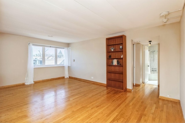 unfurnished room featuring light wood-style flooring and baseboards