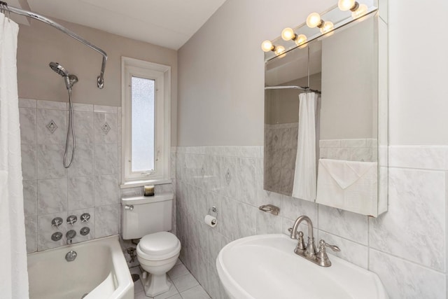 full bath featuring toilet, a sink, tile walls, tile patterned floors, and shower / bath combo