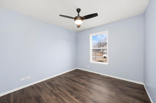 empty room with dark wood-type flooring, visible vents, baseboards, and a ceiling fan