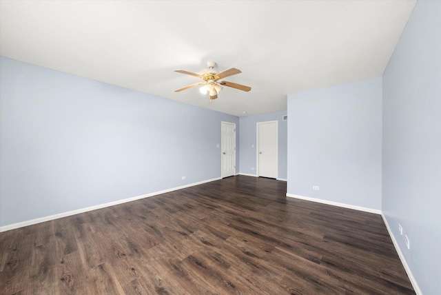 spare room with ceiling fan, dark wood-style flooring, and baseboards