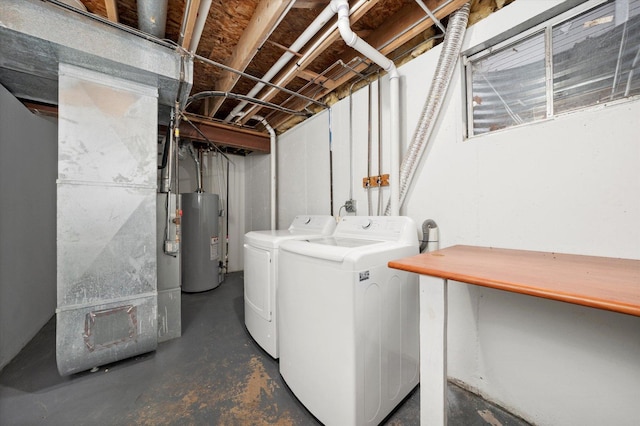 washroom with laundry area, gas water heater, washing machine and dryer, and heating unit