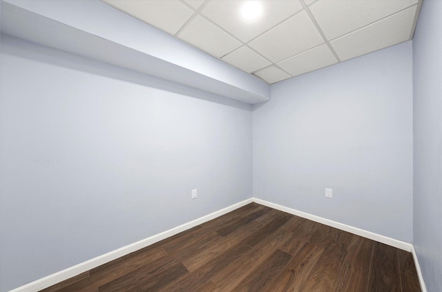 finished basement featuring baseboards, dark wood-type flooring, and a drop ceiling