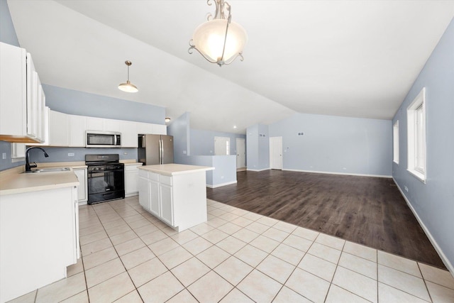 kitchen with stainless steel appliances, light countertops, light tile patterned flooring, and a sink