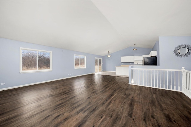 unfurnished living room featuring lofted ceiling, dark wood-style floors, and baseboards