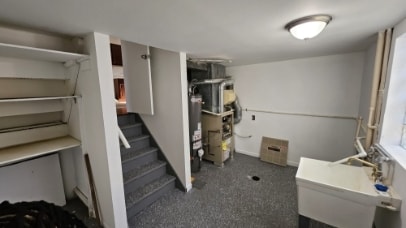 basement with a sink and stairs