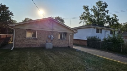 rear view of property featuring central air condition unit, a yard, and fence