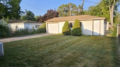 garage featuring driveway and fence