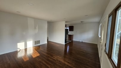 empty room featuring visible vents and dark wood-style flooring