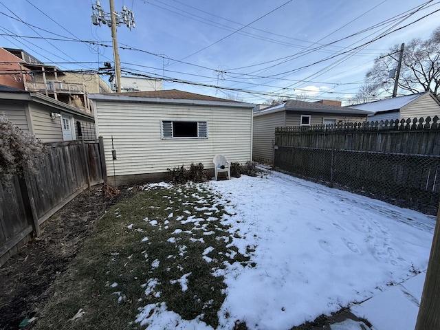 snowy yard with a fenced backyard