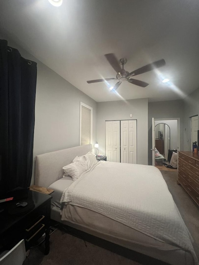 carpeted bedroom with a ceiling fan and a closet