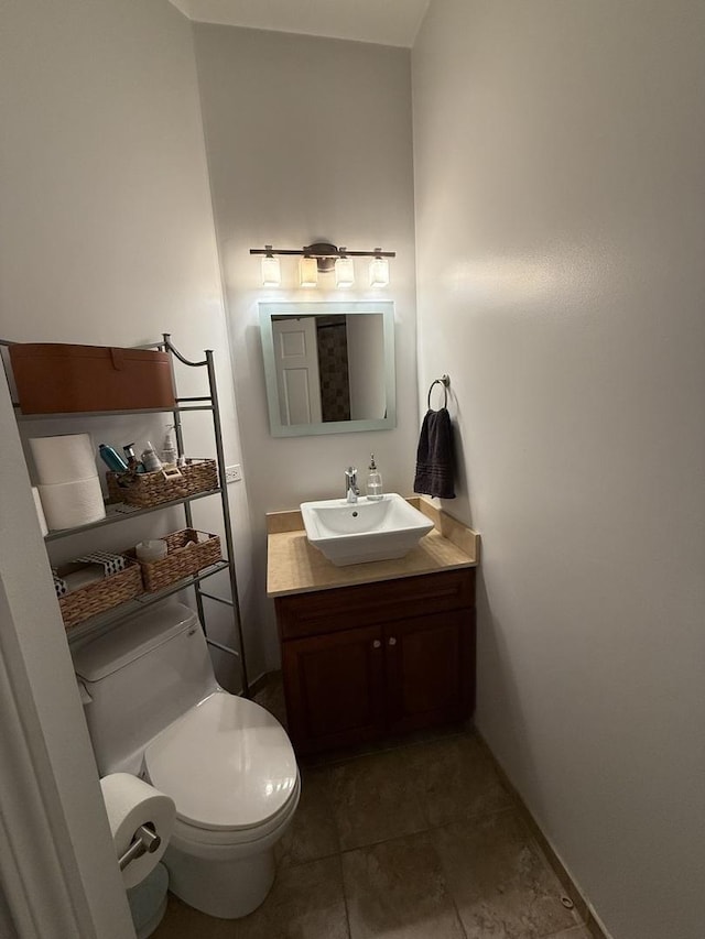 bathroom with toilet, vanity, and baseboards