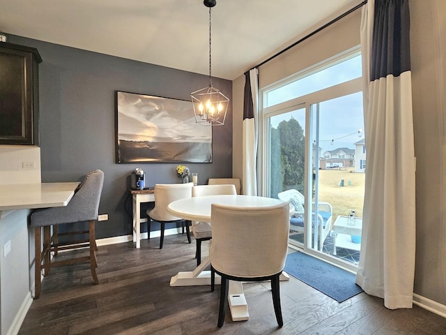 dining area featuring a chandelier, dark wood-style flooring, and baseboards