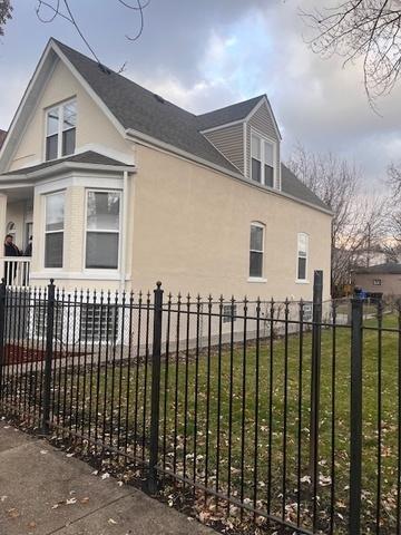 view of side of home featuring a yard, a fenced front yard, and stucco siding