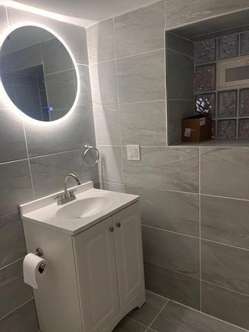 bathroom with tile patterned flooring, vanity, and tile walls