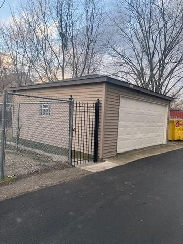 detached garage with fence and a gate