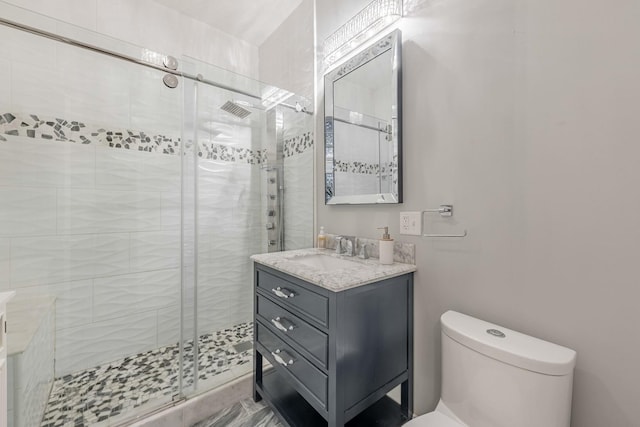 full bathroom featuring toilet, a shower stall, and vanity