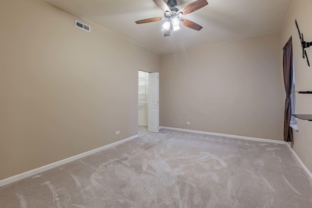 carpeted empty room featuring baseboards, visible vents, and a ceiling fan