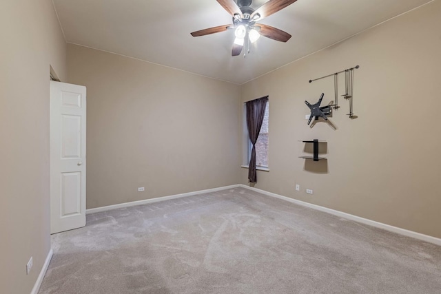 carpeted empty room featuring ceiling fan and baseboards