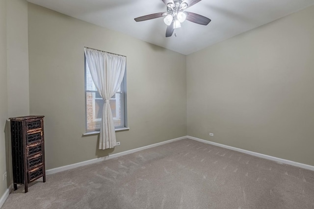 spare room featuring carpet floors, a ceiling fan, and baseboards