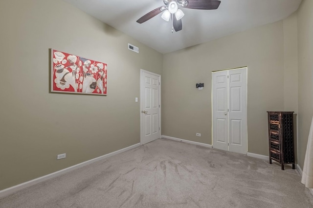 unfurnished bedroom featuring visible vents, baseboards, ceiling fan, carpet, and a closet