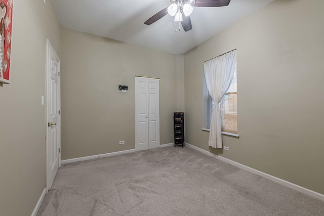 unfurnished room featuring carpet floors, baseboards, and a ceiling fan