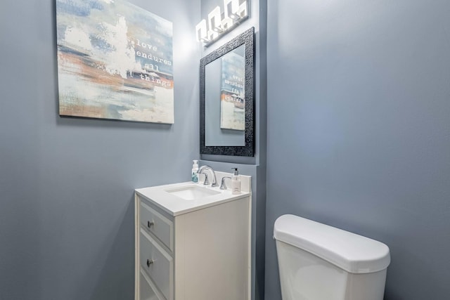 half bathroom with vanity and toilet