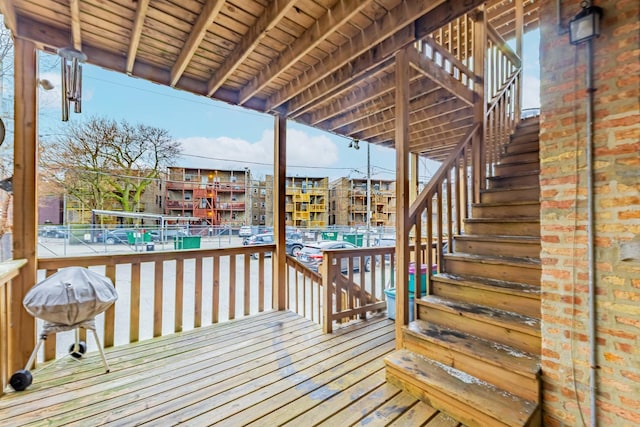 wooden deck with stairway and area for grilling