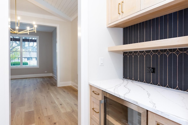 interior details featuring wine cooler, beam ceiling, an inviting chandelier, wood finished floors, and baseboards