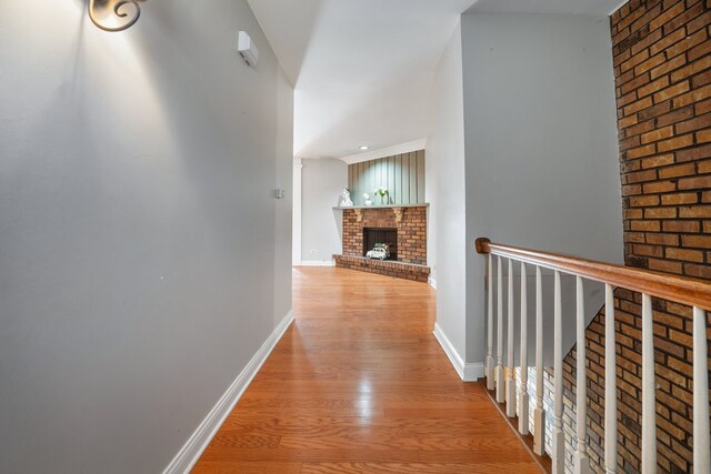 hall featuring light wood-style flooring and baseboards