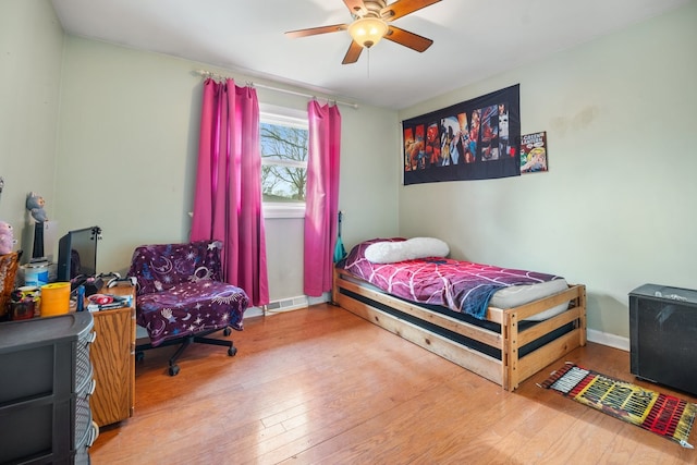bedroom with hardwood / wood-style floors, baseboards, a ceiling fan, and visible vents