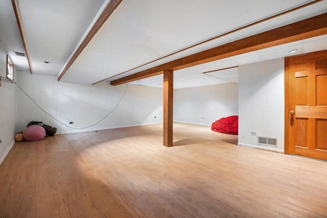 finished basement featuring baseboards, wood finished floors, and visible vents