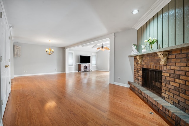 unfurnished living room featuring recessed lighting, light wood-type flooring, baseboards, a fireplace, and ceiling fan with notable chandelier