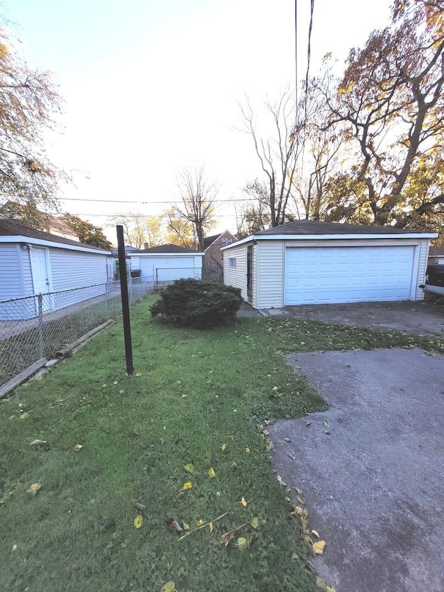 view of yard with an outbuilding, a detached garage, and fence