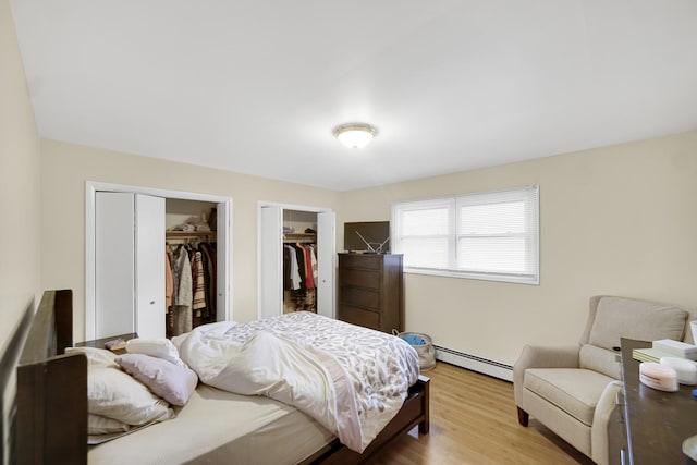 bedroom with a baseboard radiator and wood finished floors