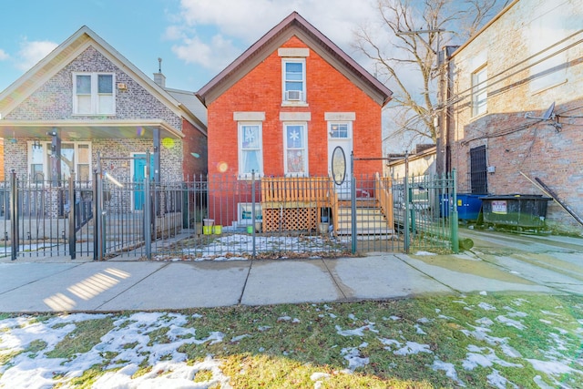 view of front facade featuring a fenced front yard, a gate, and brick siding