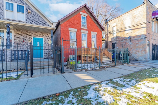 view of front facade featuring a fenced front yard, a gate, and brick siding