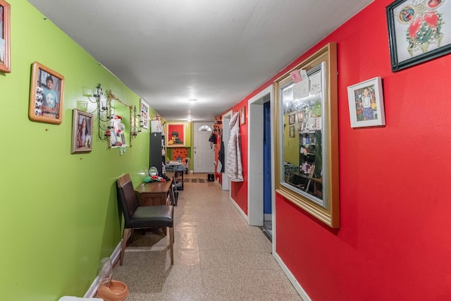 corridor featuring baseboards and tile patterned floors