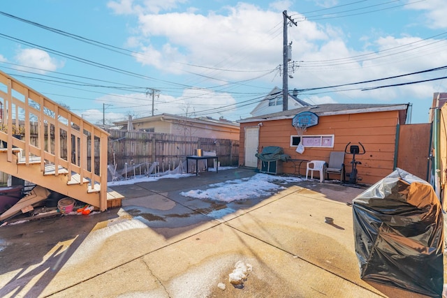 view of patio / terrace with grilling area, a fenced backyard, and an outdoor structure