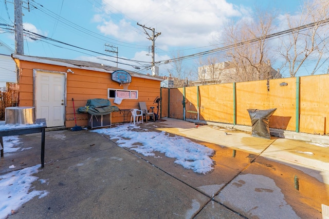 view of patio with an outbuilding, a grill, and fence