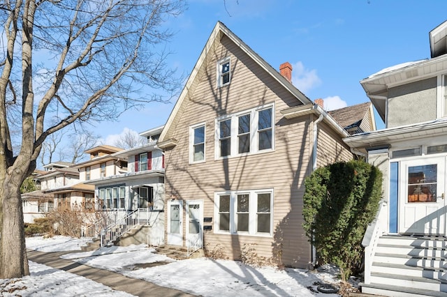 view of front of home with entry steps and a chimney