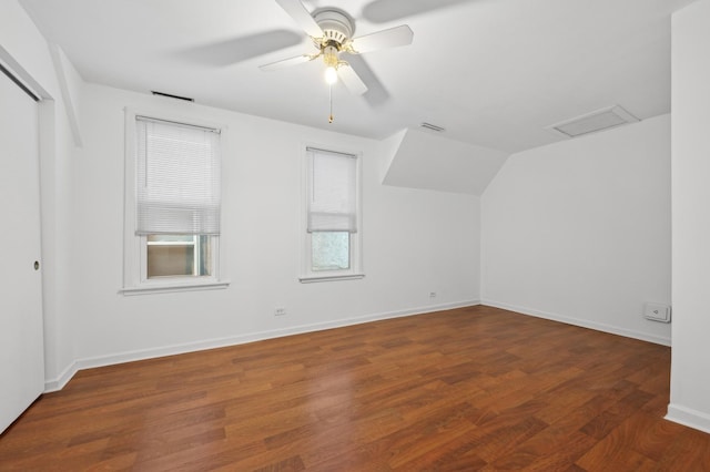 additional living space with visible vents, attic access, ceiling fan, wood finished floors, and baseboards