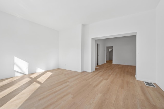 empty room with light wood-style flooring and visible vents