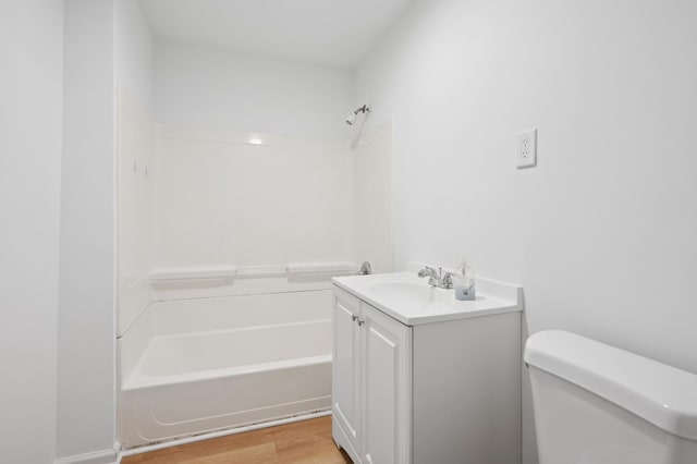 full bath featuring vanity, shower / washtub combination, wood finished floors, and toilet