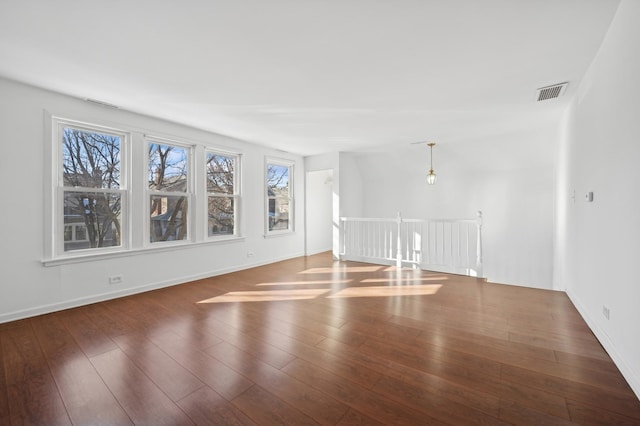 interior space with wood finished floors, visible vents, and baseboards