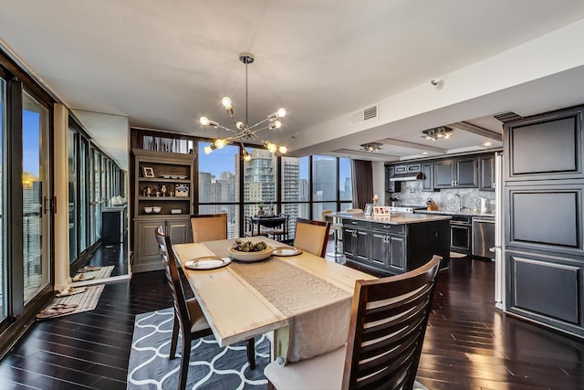 dining area with a city view, visible vents, dark wood-style floors, a wall of windows, and an inviting chandelier