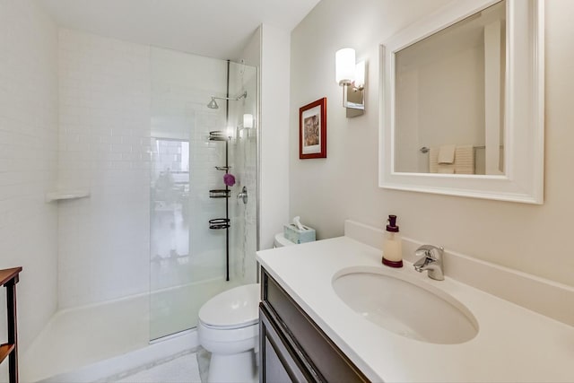 full bath with toilet, tiled shower, and vanity