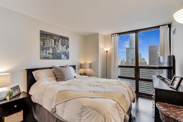 bedroom with a wall of windows, wood finished floors, and visible vents