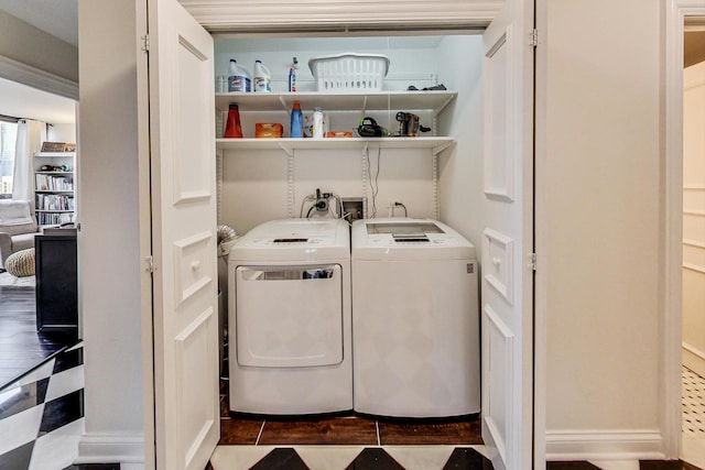 clothes washing area featuring washing machine and dryer, laundry area, and wood finished floors