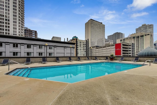 community pool with a view of city and a patio area